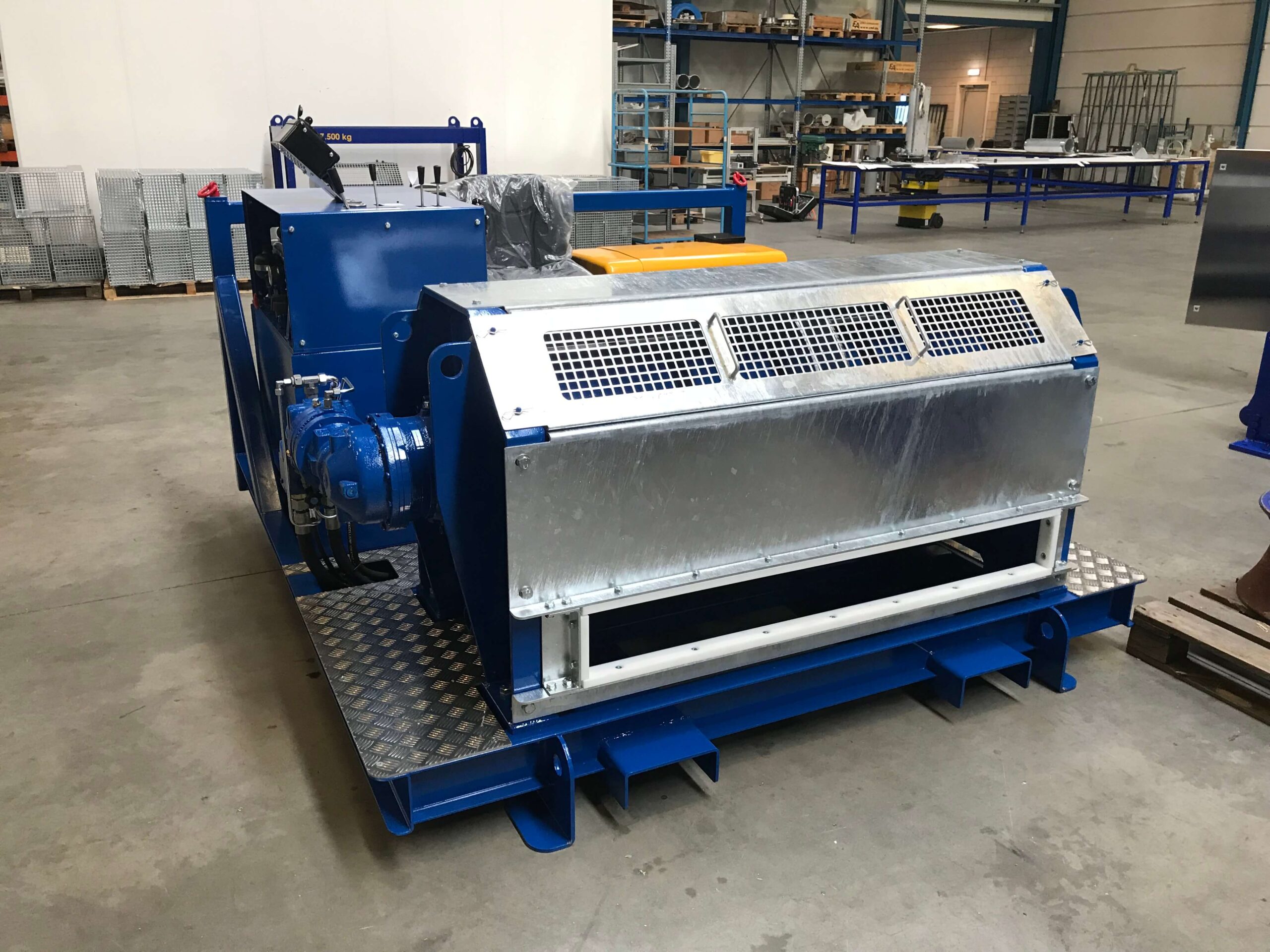 Industrial machinery with a blue and silver metal casing sits on a factory floor.